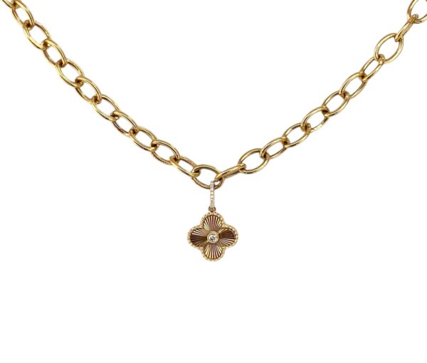 Yellow gold clover flower pendant necklace with a radiant diamond at its center, paired with a bold, chunky gold chain — a striking blend of timeless elegance and modern flair.