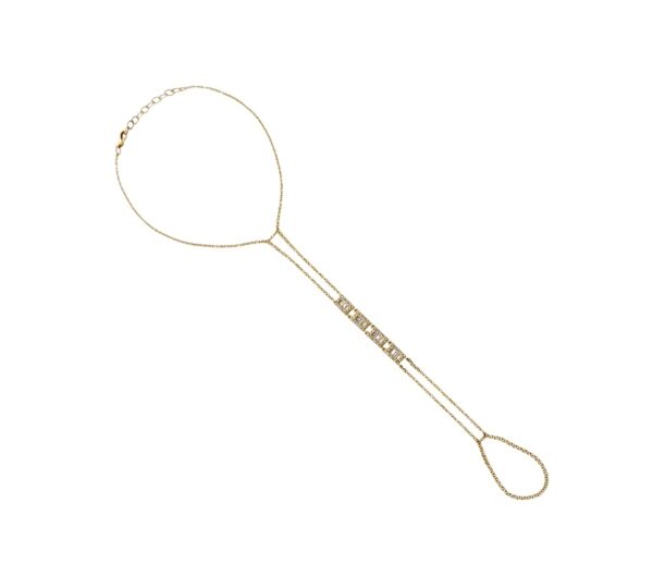 Gold hand chain styled on a model’s hand, featuring a fine chain with rectangular baguette diamonds connecting a bracelet to a ring, shown on a neutral background.