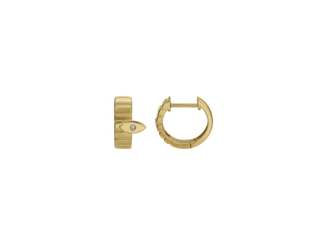 Yellow gold huggie earrings with ridged texture and a small evil eye charm featuring a single diamond in the center of the evil eye.